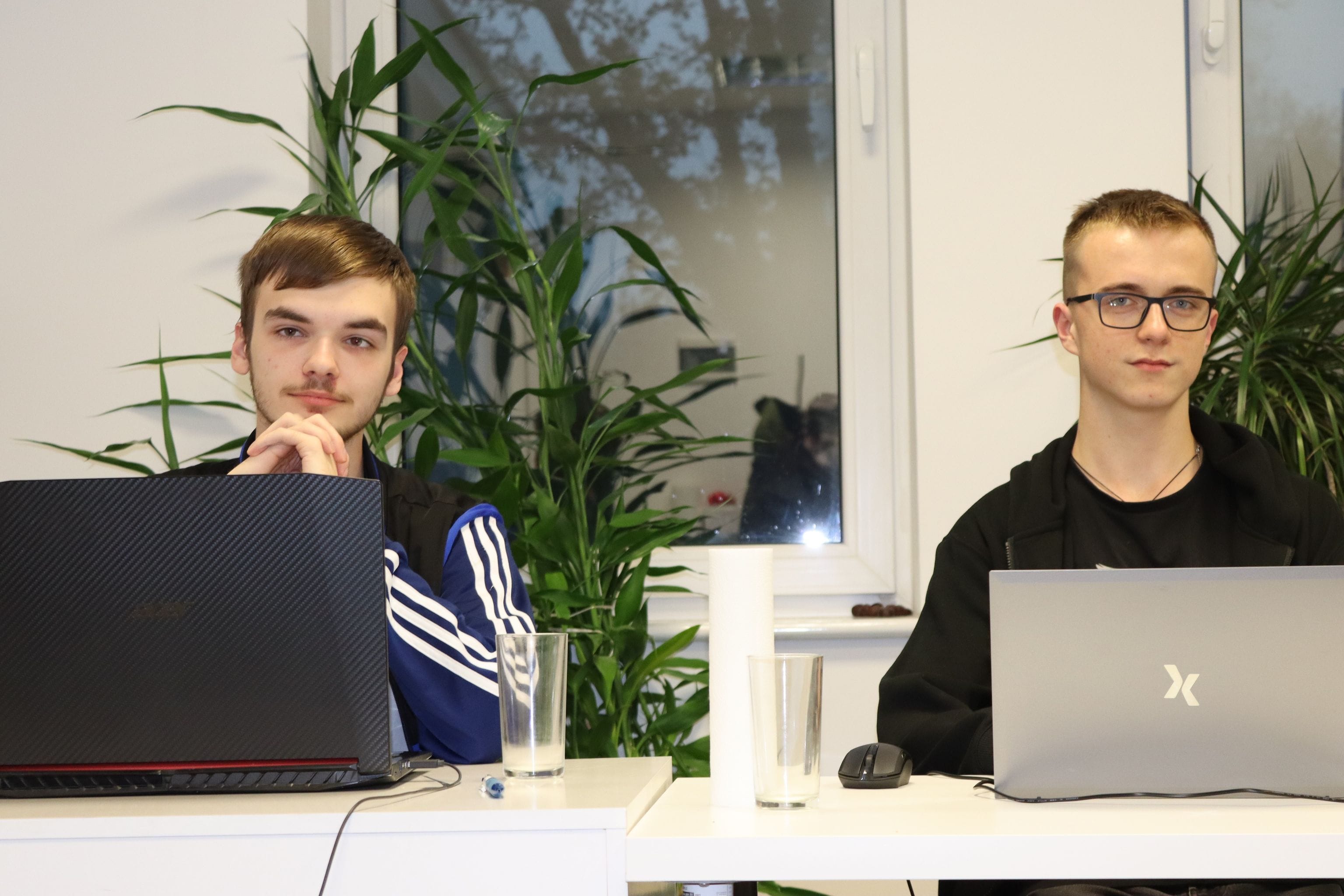 Two young men with laptops in the office